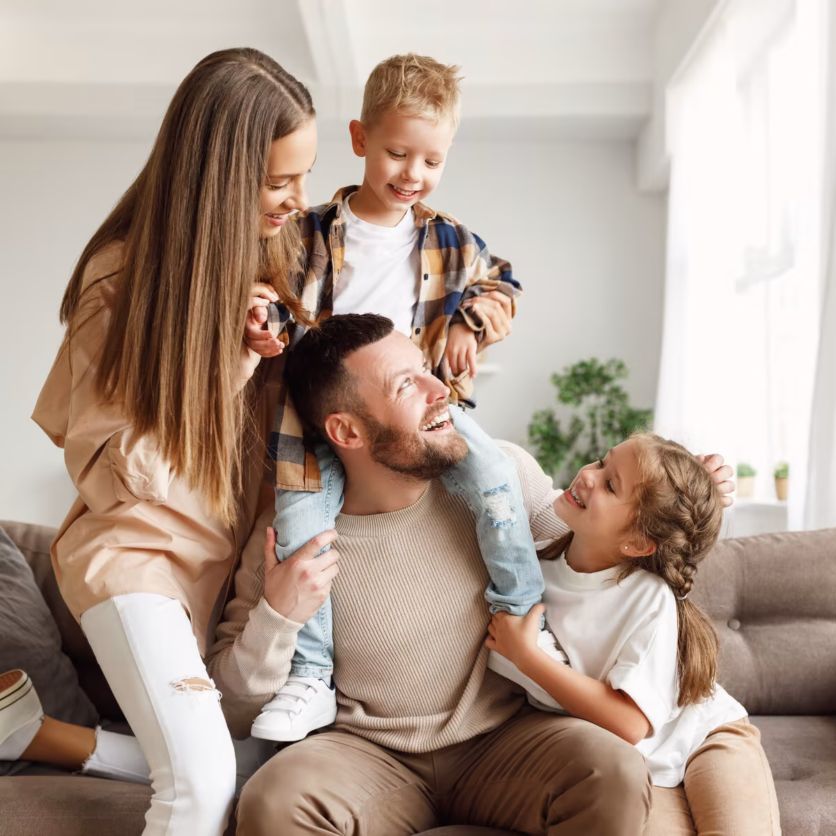 Happy parents playing with their two children at home