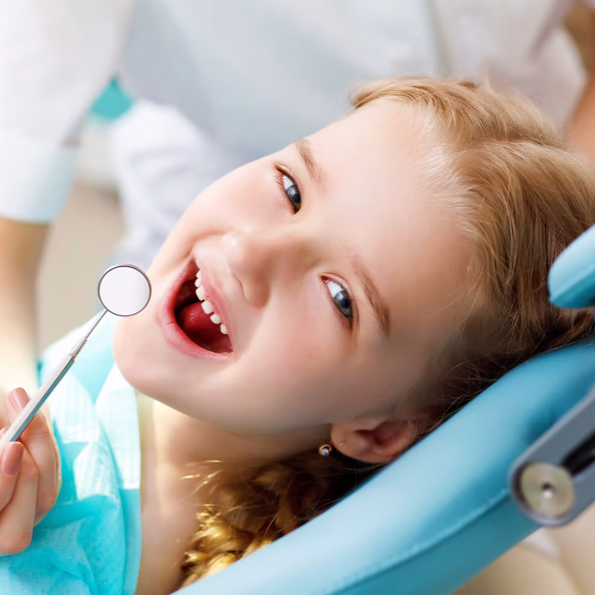 Smiling girl relaxing in a pediatric dental chair